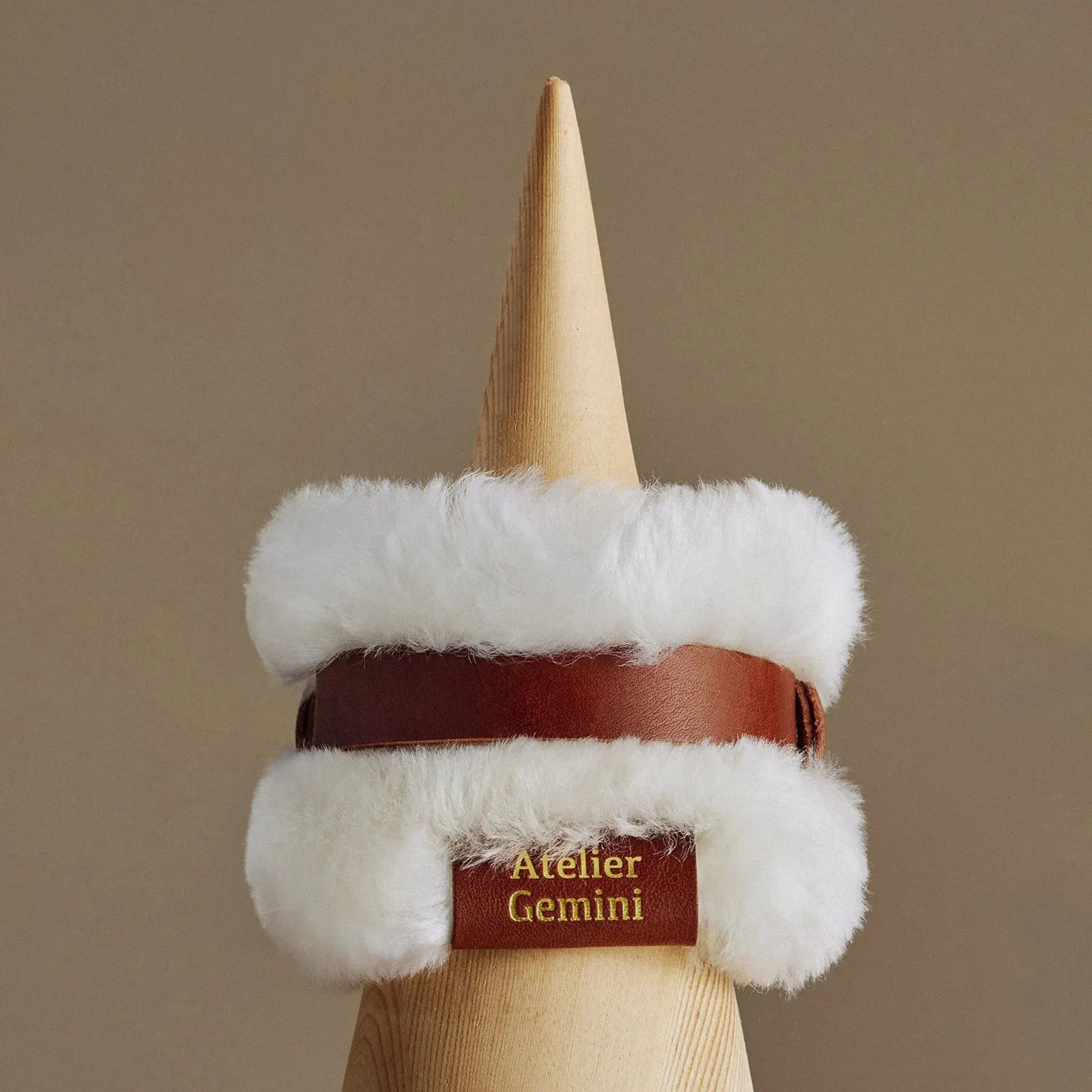 Gros plan sur collier artisanal en cuir italien avec rouleau de laine d'agneau montrant la qualité de fabrication haut de gamme