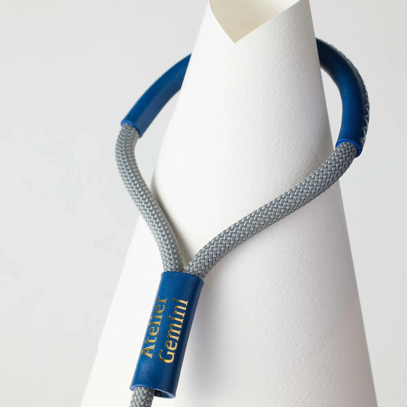 Gros plan sur la poignée en cuir bleu épais d'une laisse premium pour chien